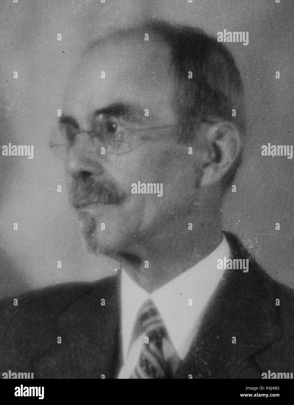 Kopf geschossen von John Jacob Abel, ein original Mitglied der Fakultät von der Johns Hopkins University Medizin, trug einen dunklen Anzug und eine gestreifte Krawatte mit einem weißen Hemd, trug Rundschreiben rahmenlose Brille, zu seiner Rechten, vor dem Hintergrund gestellt, mit einem ernsten Gesichtsausdruck. 1931. Stockfoto