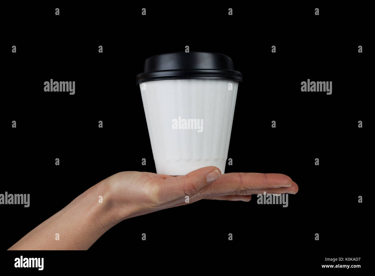 Weibliche hand mit weiß Einweg Kaffeetasse in der Palm isoliert auf Schwarz mit Kopie Raum Stockfoto