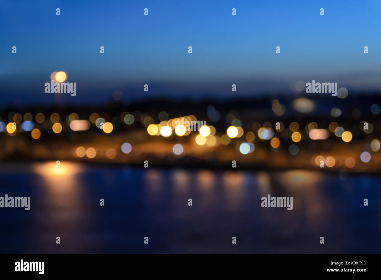 Lichter der Stadt Küstenlinie mit schönen Bokeh Effekt auf dem Hintergrund des blauen Himmels am Abend. Stockfoto