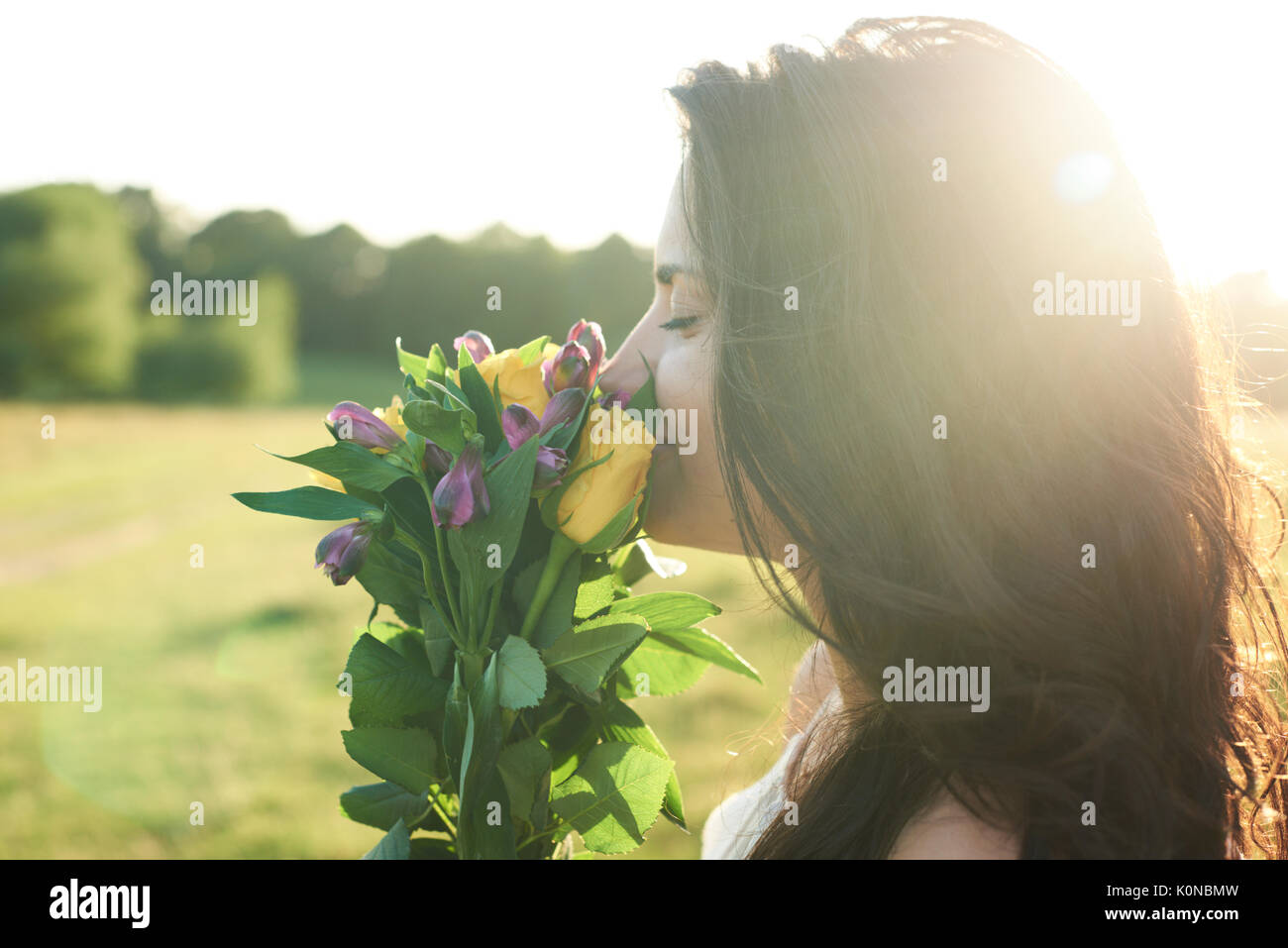 Hampstead Heath, London, UK, Portrait eines hübschen Mädchens duftende Blumen, Sonnenuntergang im Park Stockfoto