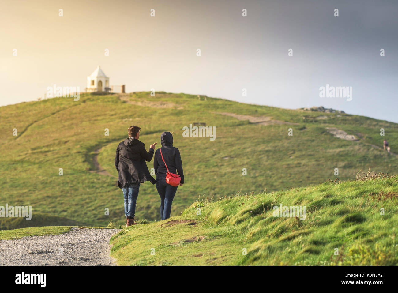 Ein Paar genießt einen Spaziergang auf dem Küstenwanderweg, der nach Towan Head in Newquay, Cornwall führt. Stockfoto