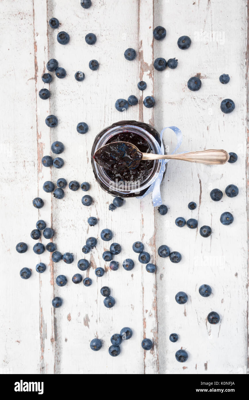 Glas blueberry Jam und Heidelbeeren auf weißem Holz Stockfoto