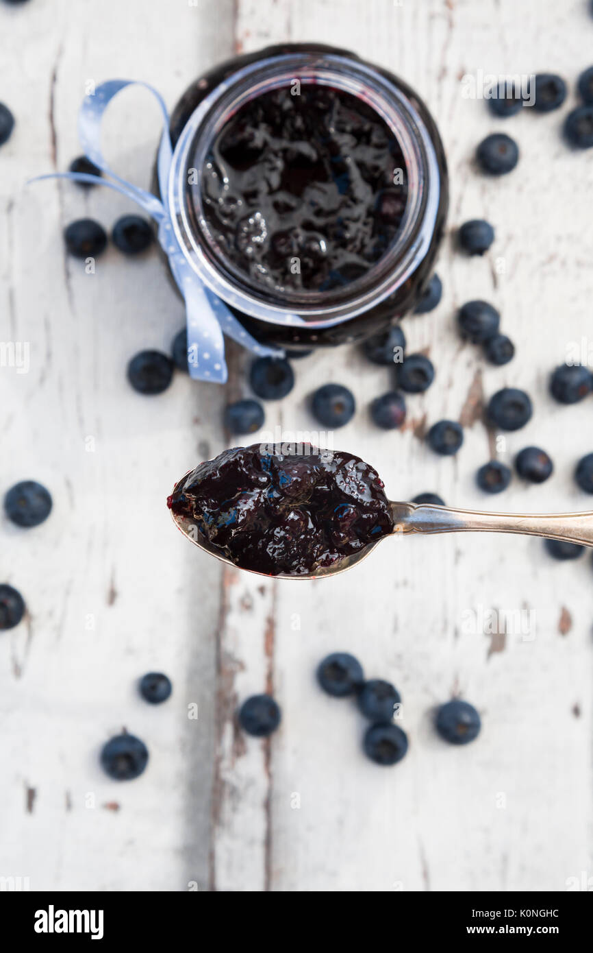 Löffel und Glas blueberry Jam und Blaubeeren Stockfoto
