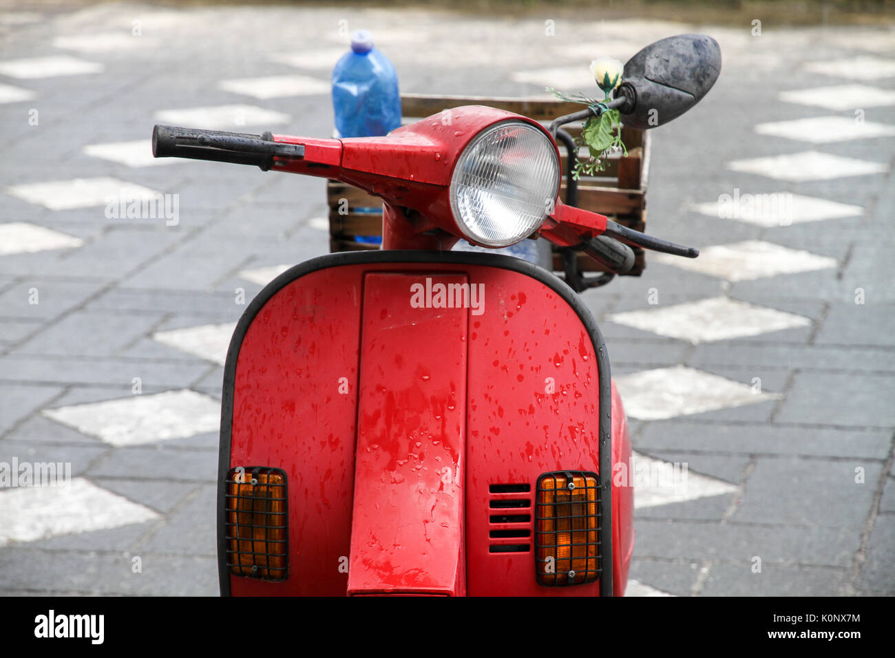 Red vintage Italienische roller Motorrad mit einem hinteren Korb und mit Blumen dekoriert. Stockfoto