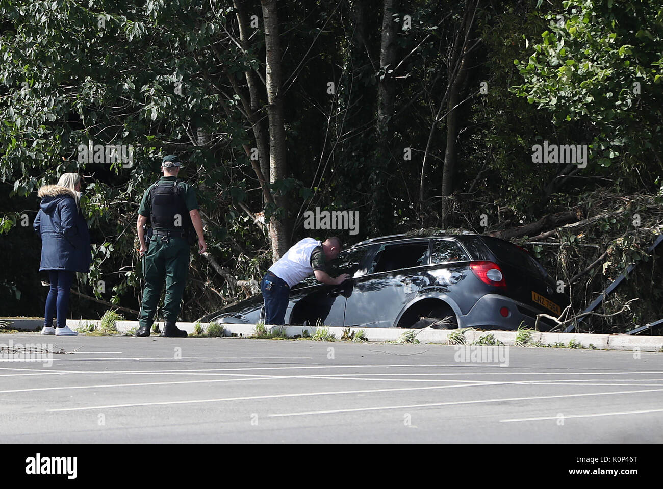 Leute schauen auf beschädigten Autos in Drumahoe, Londonderry, nach starkem Regen eine Spur der Verwüstung hinterlassen. Stockfoto