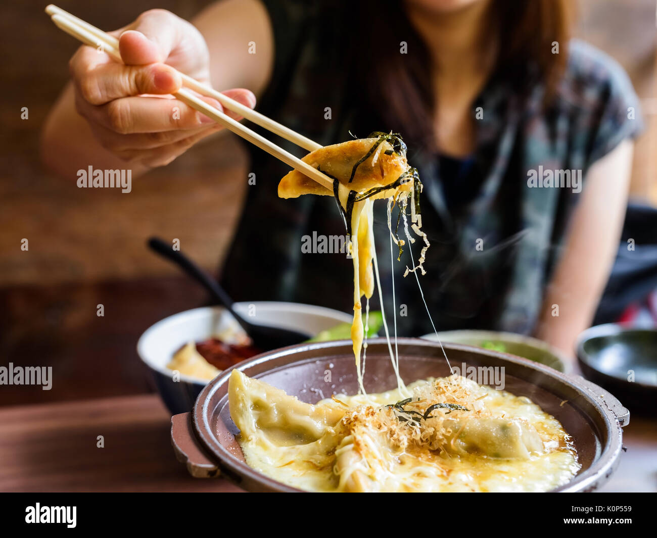 Gyoza mit Käse schmelzen von Stäbchen auf Mädchen Hände nahm Stockfoto