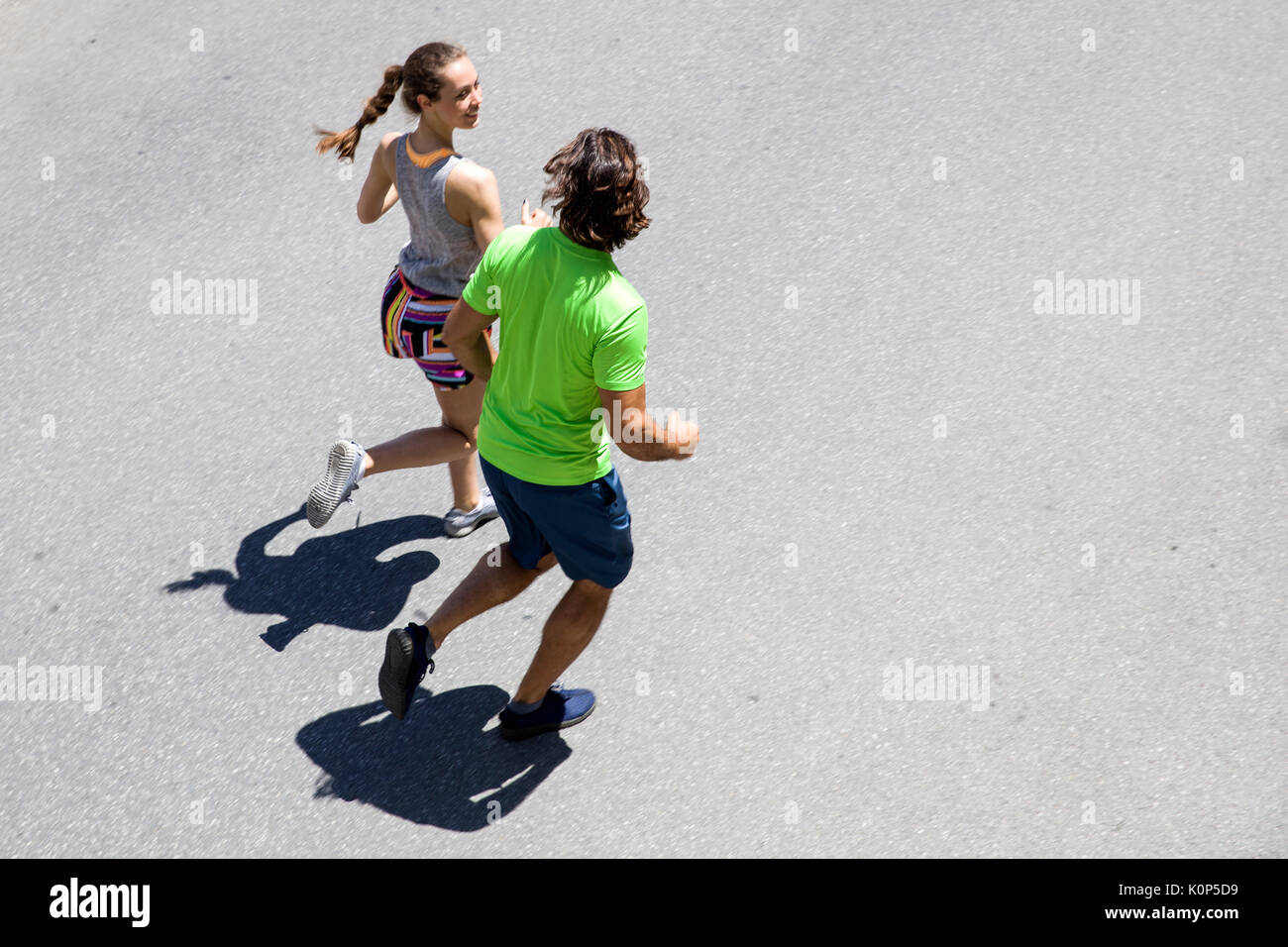 Schöner Mann und schöne Frau joggen zusammen auf der Straße an einem sonnigen Tag Stockfoto
