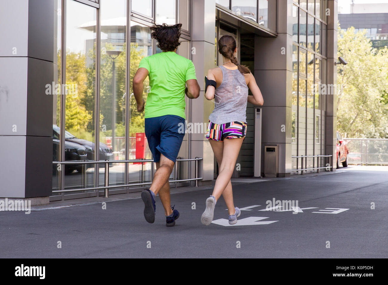 Schöner Mann und schöne Frau joggen zusammen auf der Straße an einem sonnigen Tag Stockfoto
