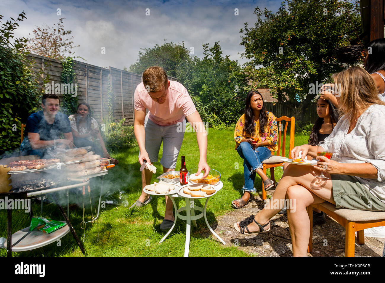 Ein junger Mann kochen Essen in einer traditionellen Familie Grill, Sussex, UK Stockfoto