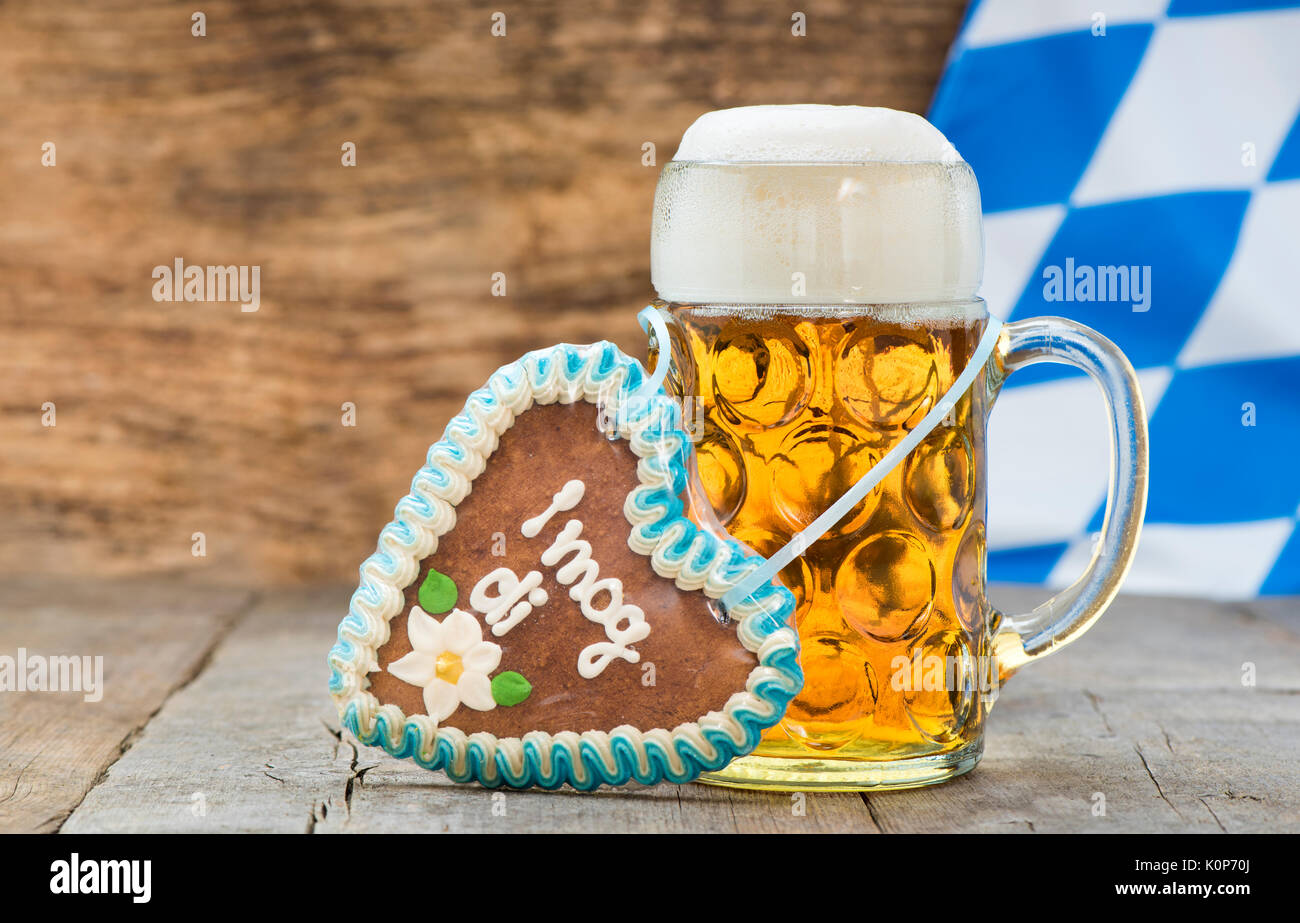 Großes Glas Lagerbier in Bayern auf dem Oktoberfest in München und süsses Herz mit Lebkuchen und Beschriftung deutsch: Ich liebe dich Stockfoto