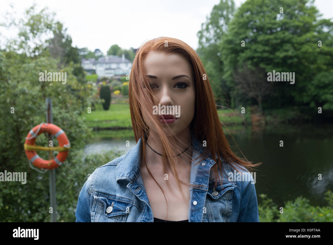 Nahaufnahme, Porträt der jungen Frau, die gegen See im Park Stockfoto