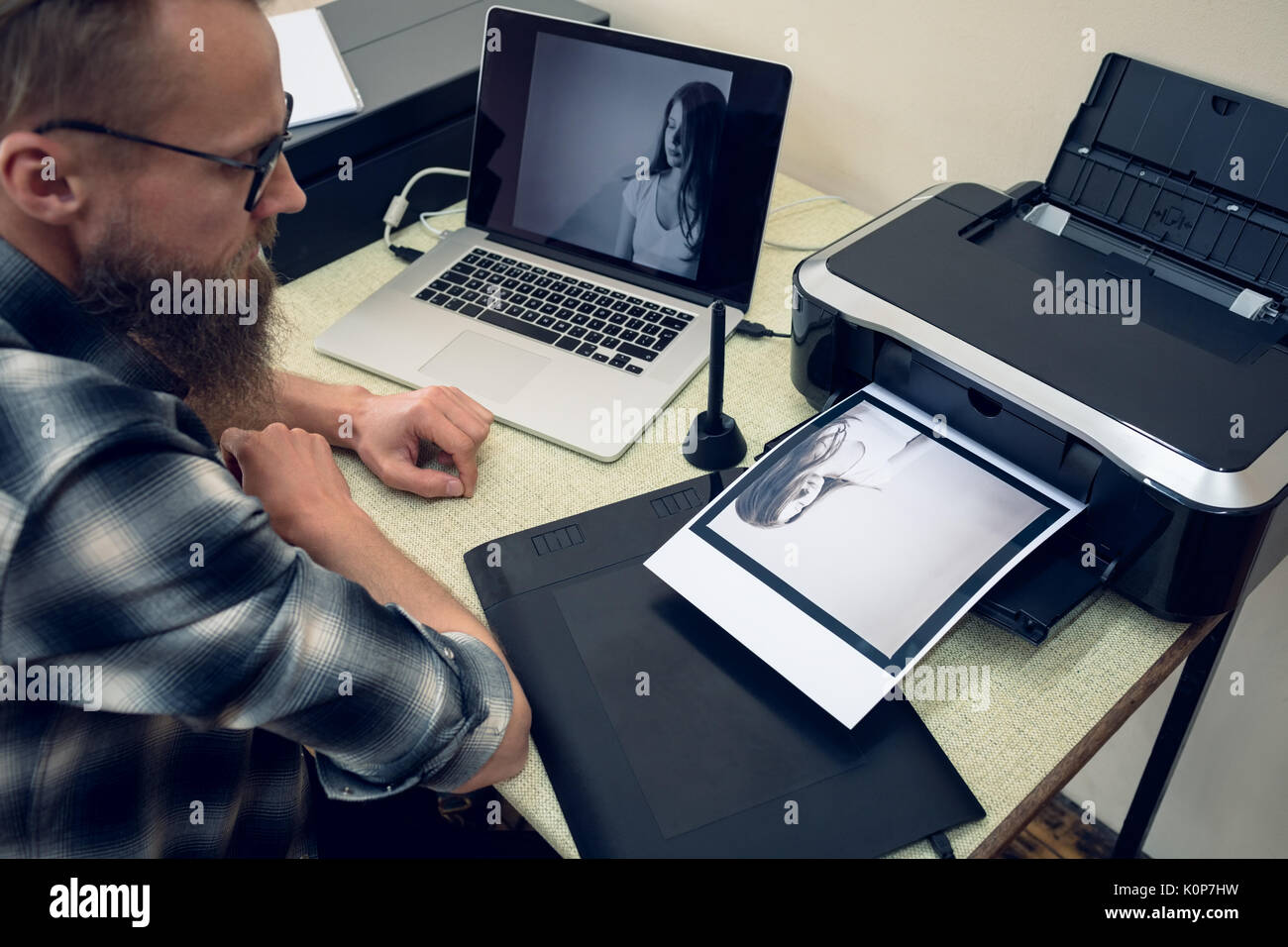 Hohe Betrachtungswinkel und der Fotograf bei Foto ausdrucken, während bei Tisch arbeiten Stockfoto