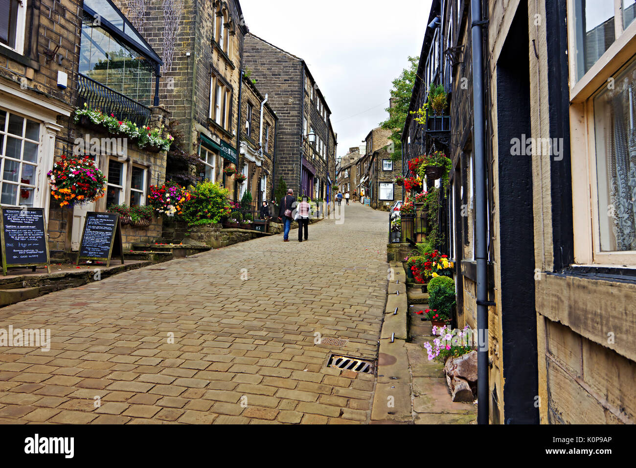 Menschen zu Fuß rund um den gepflasterten Hauptstraße im historischen Dorf Haworth, West Yorkshire, England, UK. Stockfoto