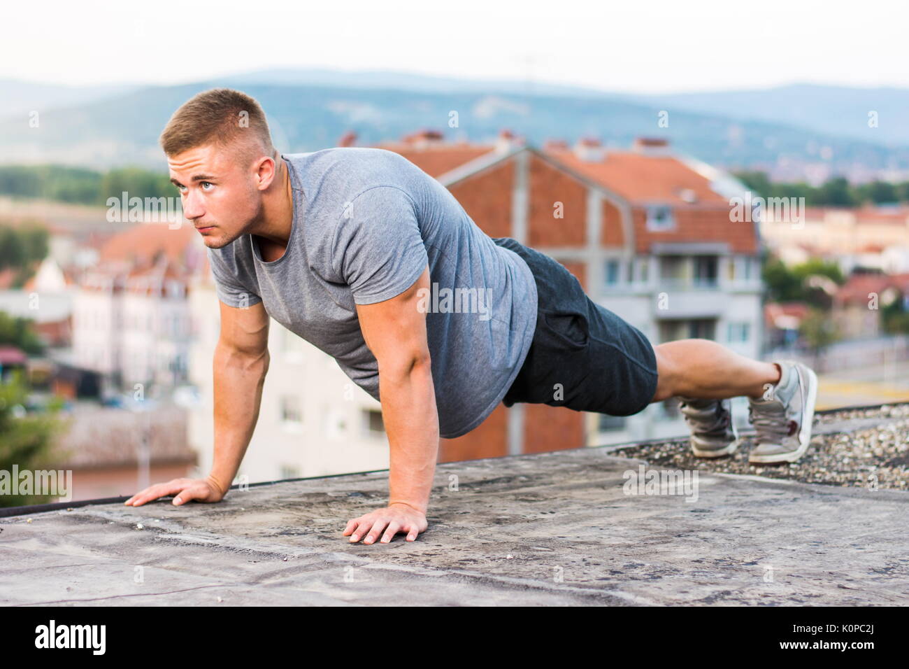 Mann, die Push-ups auf der Dachterrasse, im Freien Training Stockfoto