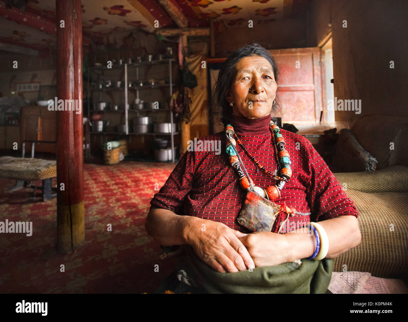 Die tibetischen Hausfrau in ihrer traditionellen home das Tragen der traditionellen Zubehör für Ihren Stamm, tibetischen Plateau Stockfoto