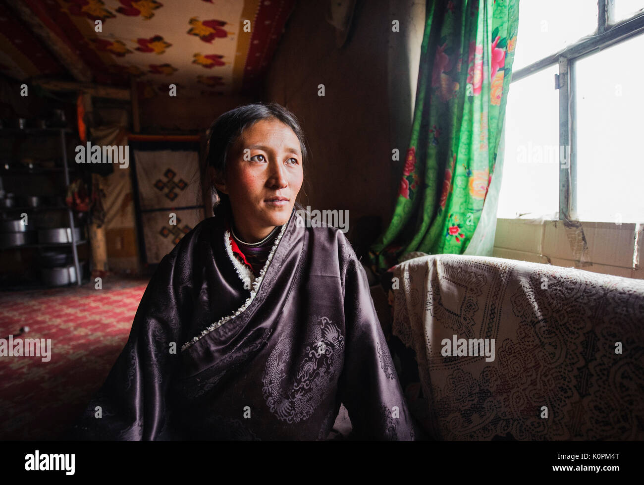 Eine junge tibetische Frau an ihr traditionelles Haus, tibetischen Plateau Stockfoto