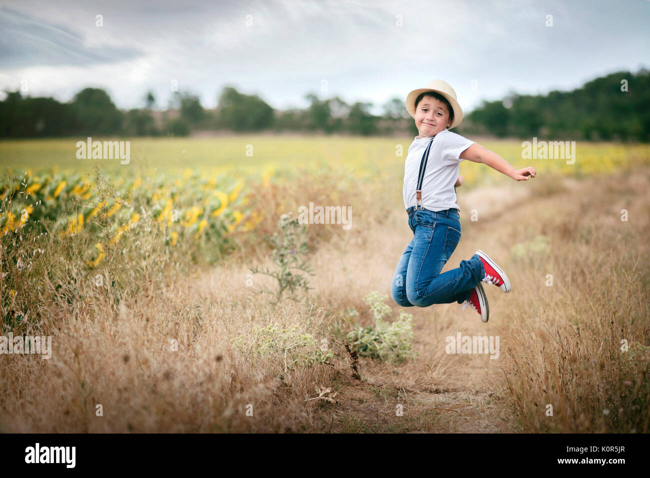 Lächelnde junge Springen in das Feld Stockfoto