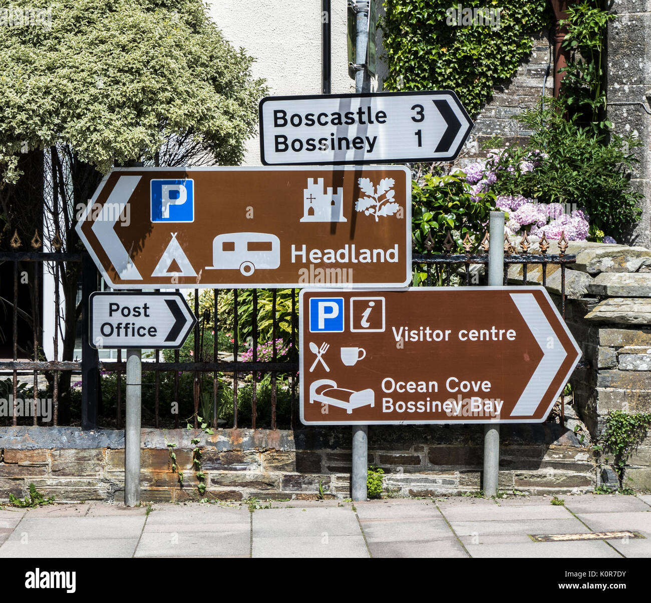 Mehrere Zeichen zu den verschiedenen Orten und touristischen Einrichtungen, in der kleinen Stadt von Tintagel, Cornwall, England, Großbritannien. Stockfoto