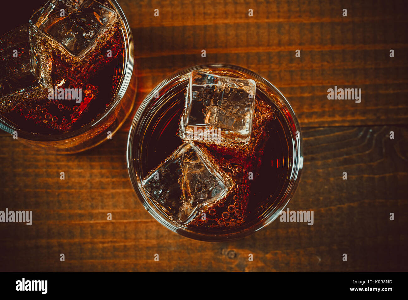 Schöne kalte fizzy cola Soda mit Würfeln Eis in Gläser Becher auf alten Holz- Hintergrund mit freier Speicherplatz Stockfoto