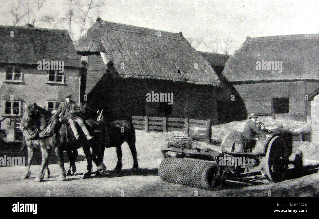 Ca. Norden-Farm Arbeitnehmer bei Brent Pelham, Hertfordshire mit beiden Pferden, einem motorisierten Schlepper und reetgedeckte landwirtschaftliche Gebäude Stockfoto