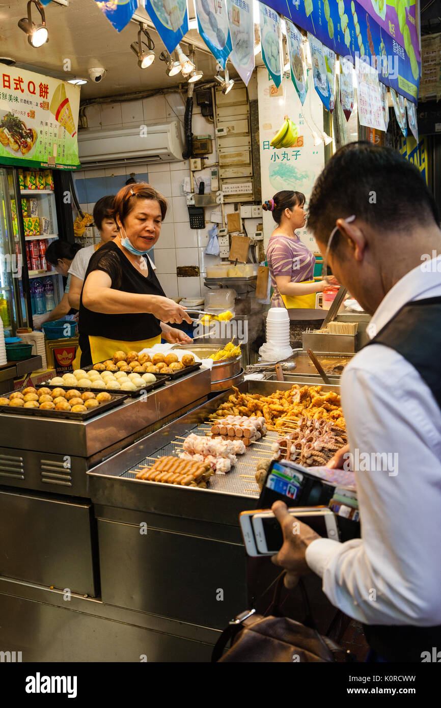 Hongkong - 11. Juli 2017: einem Straßenhändler verkaufen beliebte Snacks bei Fa Yuen Street Night Market in Kowloon. Dazu gehören stinky Tofu, Schweinedarm Stockfoto