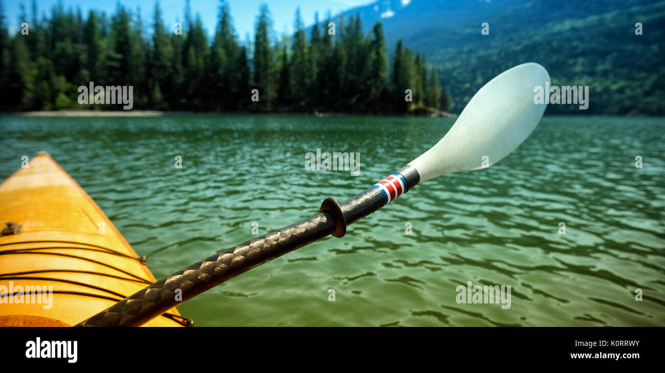 Ruder im Kajak über den See gegen Berg Stockfoto