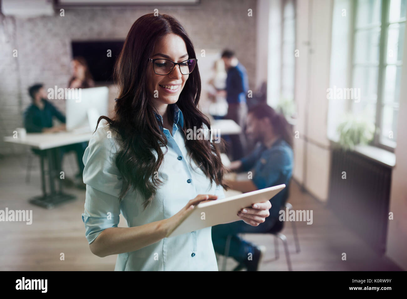Porträt der jungen schönen Frau Designer über Tablet Stockfoto