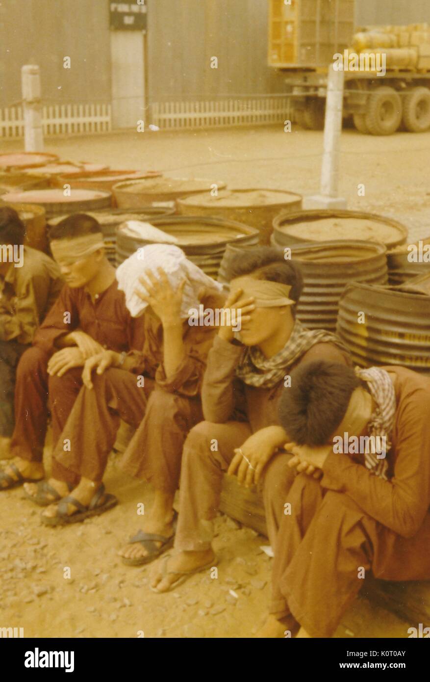 Viet Cong Soldaten gefangengenommen, Teil der Nationalen Befreiungsfront, werden zu sitzen mit ihren Augen, sich an einem Ort befindet, der von der US-Armee besetzt, Can Tho, Vietnam, 1964. Stockfoto