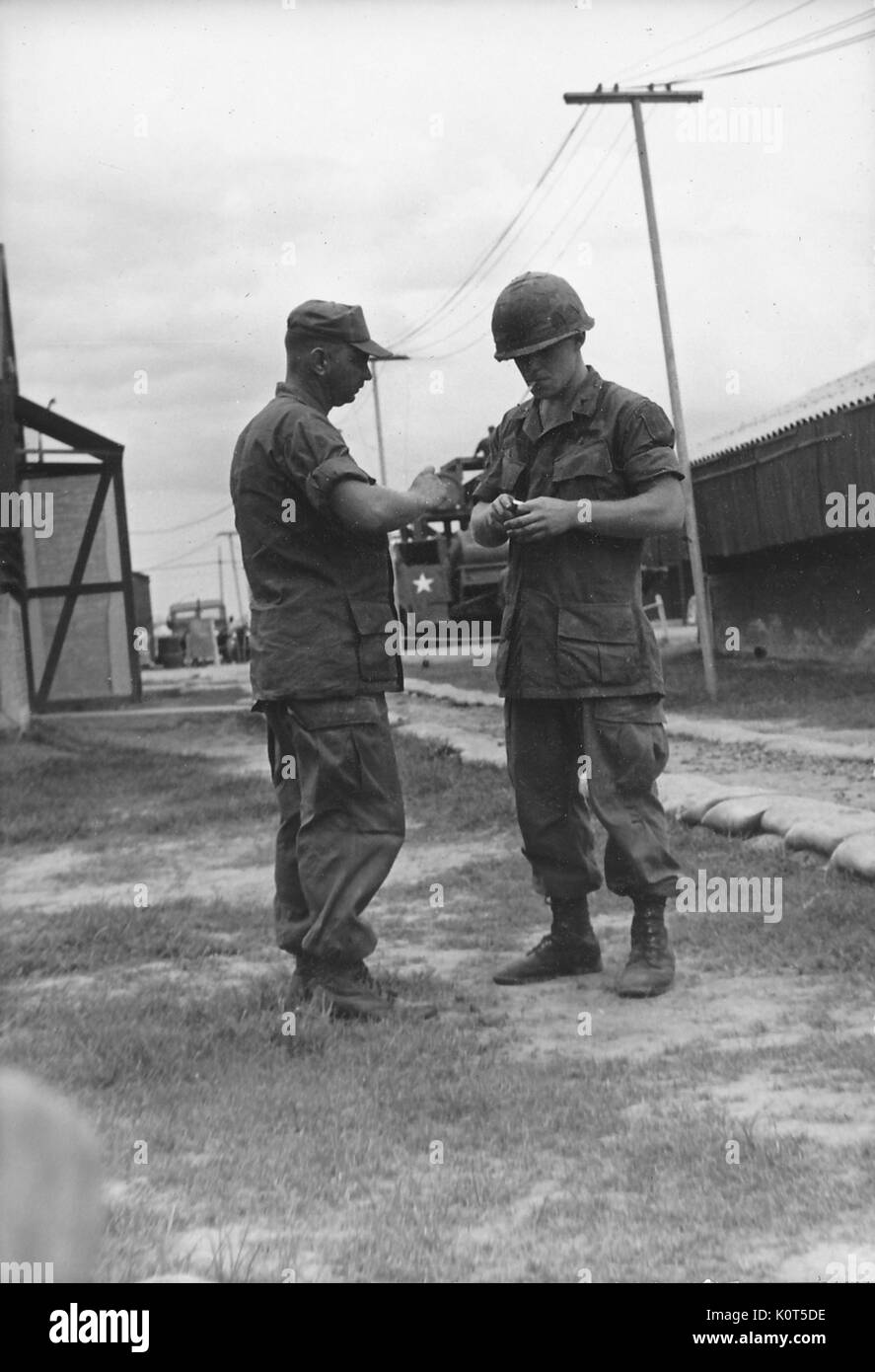 Ein Foto von zwei United States Army Soldaten im Kampf Uniformen sprechen auf ihre Basis, Vietnam, 1967. Stockfoto