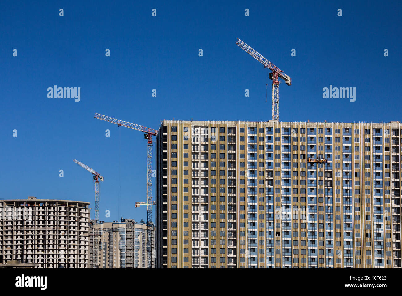 Dekoration Arbeit der Fassade von Bauherren in einem Bau Wiege der neuen Wohngebäuden und Turmdrehkrane Stockfoto