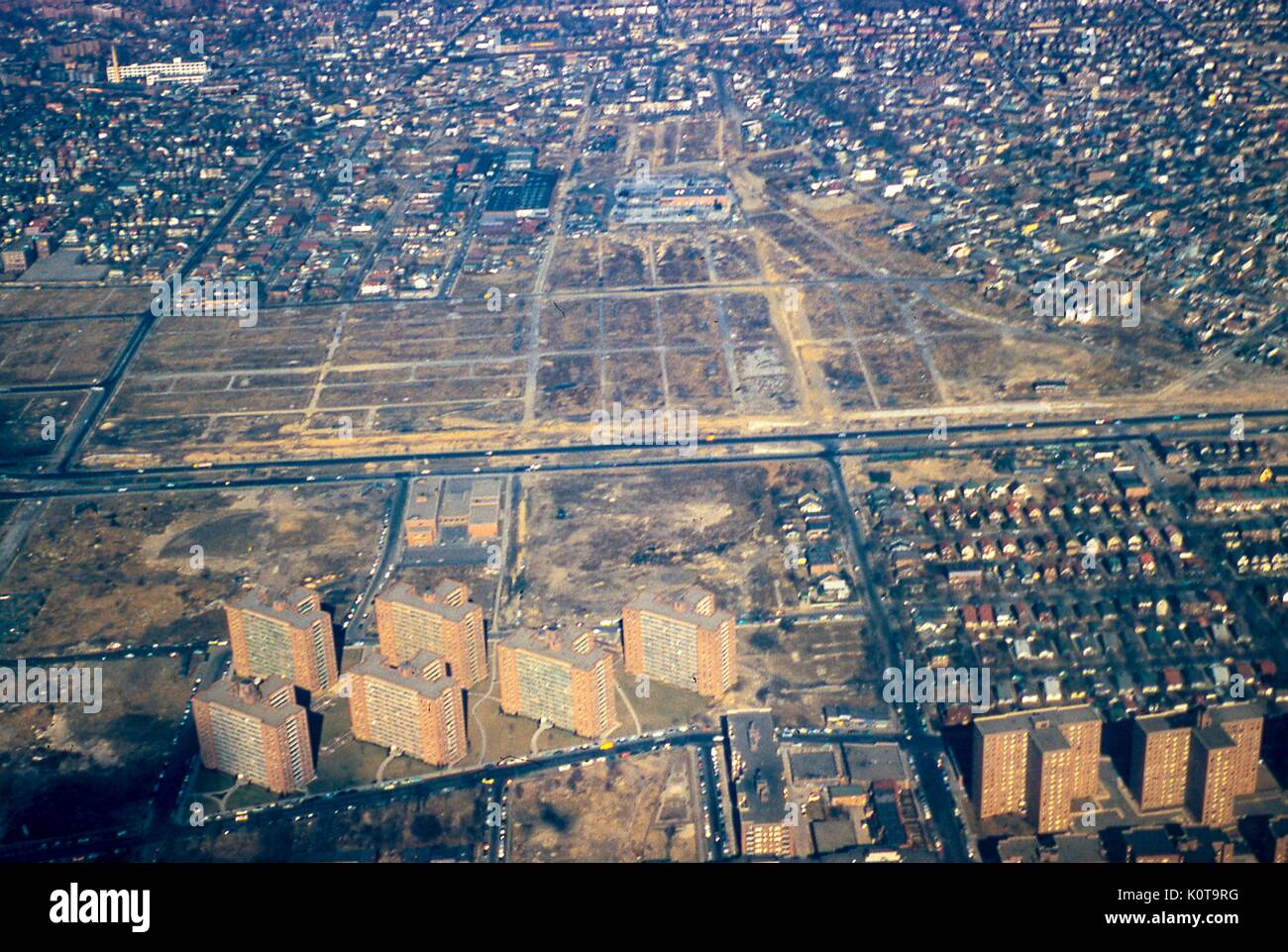 Luftaufnahme nördlich der Nachbarschaften Rego Park, Elmhurst und Corona, Queens, New York City, 1957. Der Long Island Expressway (LIE) verläuft horizontal Ost-West am Mittelrahmen. Auf dem leeren Land nördlich der Westbahn LIE wird der Apartmentkomplex Lefrak City mehrere Jahre nach der Aufnahme dieses Fotos errichtet. Das eineinbahnige Gebäude in der Mitte ist die Consolidated Edison elektrische Umspannstation an der 9th Street und 55th Avenue. Die Bahngleise der Long Island Railroad (LIRR) nach Forest Hills verlaufen parallel zur LIE entlang der oberen Rahmenkante. Kreuzung Boulevard kreuzt t Stockfoto