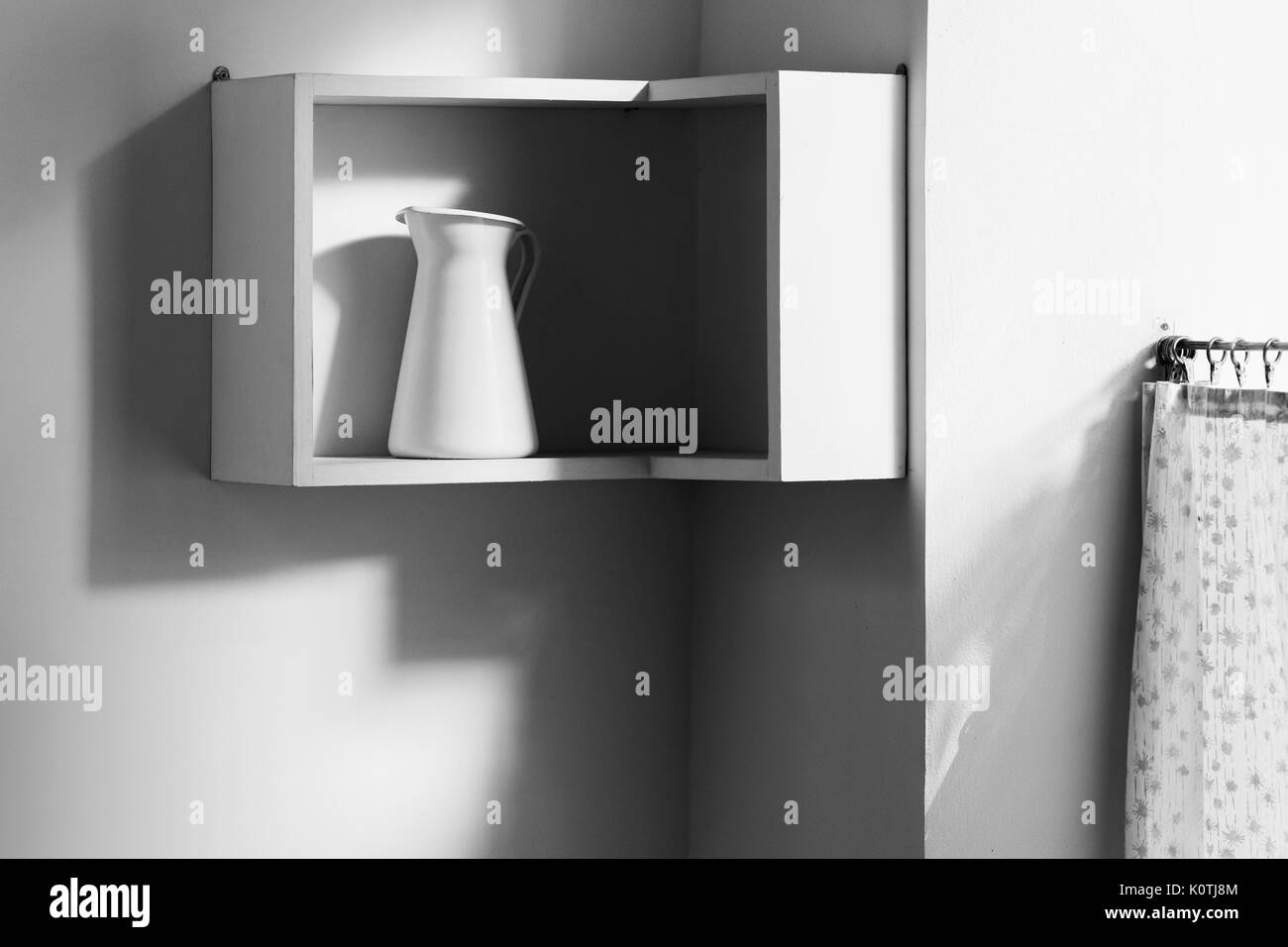 Minimalistisches Interieur der Weißen Moderne Küche. Eine isolierte Kanne auf Regal und Licht vom Fenster Stockfoto