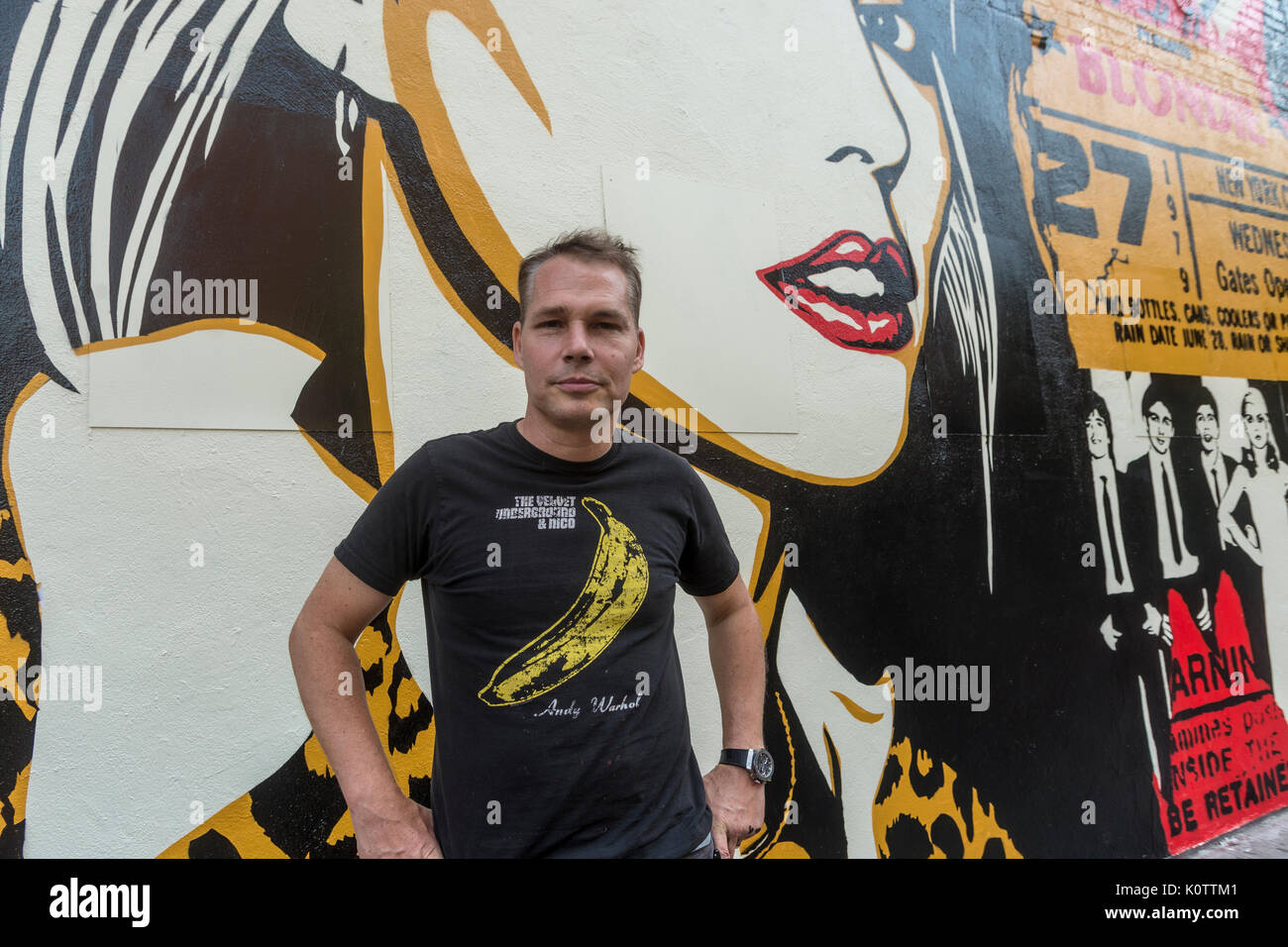 New York, USA. 23 Aug, 2017. Shepard Fairey, und seine neu abgeschlossen Wandbild. Das Wandbild mit Debbie Harry, Sänger für die Gruppe Blondie, die ihren Start in 1979 erhielt im CBGB, auf der anderen Straßenseite war. Fairy Arbeiten ist auch in Blondie's neuestes Album "Polinator", welches im Mai 2017 veröffentlicht wurde. Credit: Stacy Walsh Rosenstock/Alamy leben Nachrichten Stockfoto