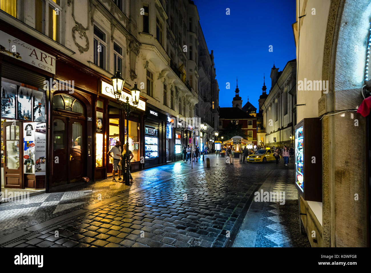 Bunte Abend Foto einer kleinen Straße in der Altstadt von Prag in der Dämmerung mit Käufern und eine Kabine mieten Stockfoto