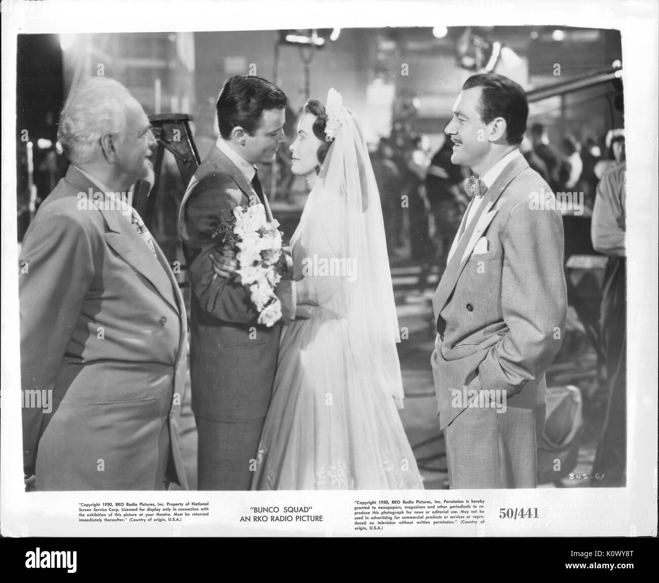 Ein Film noch Szene aus 'Bunco Squad" (1950 semi-dokumentarischen Film von RKO Radio Pictures vertrieben), ein junges Paar, das nach einander in einer Hochzeit Ritus während zwei Männer, einer auf jeder Seite sehen Sie glücklich, 1950. Stockfoto
