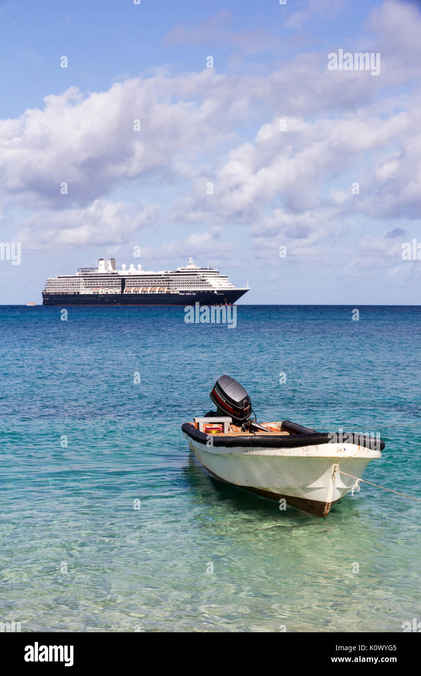 Kleines Boot verankert auf Dravuni Island, Fidschi, South Pacific mit der Holland America Line Kreuzfahrtschiffe Oosterdam im Hintergrund Stockfoto