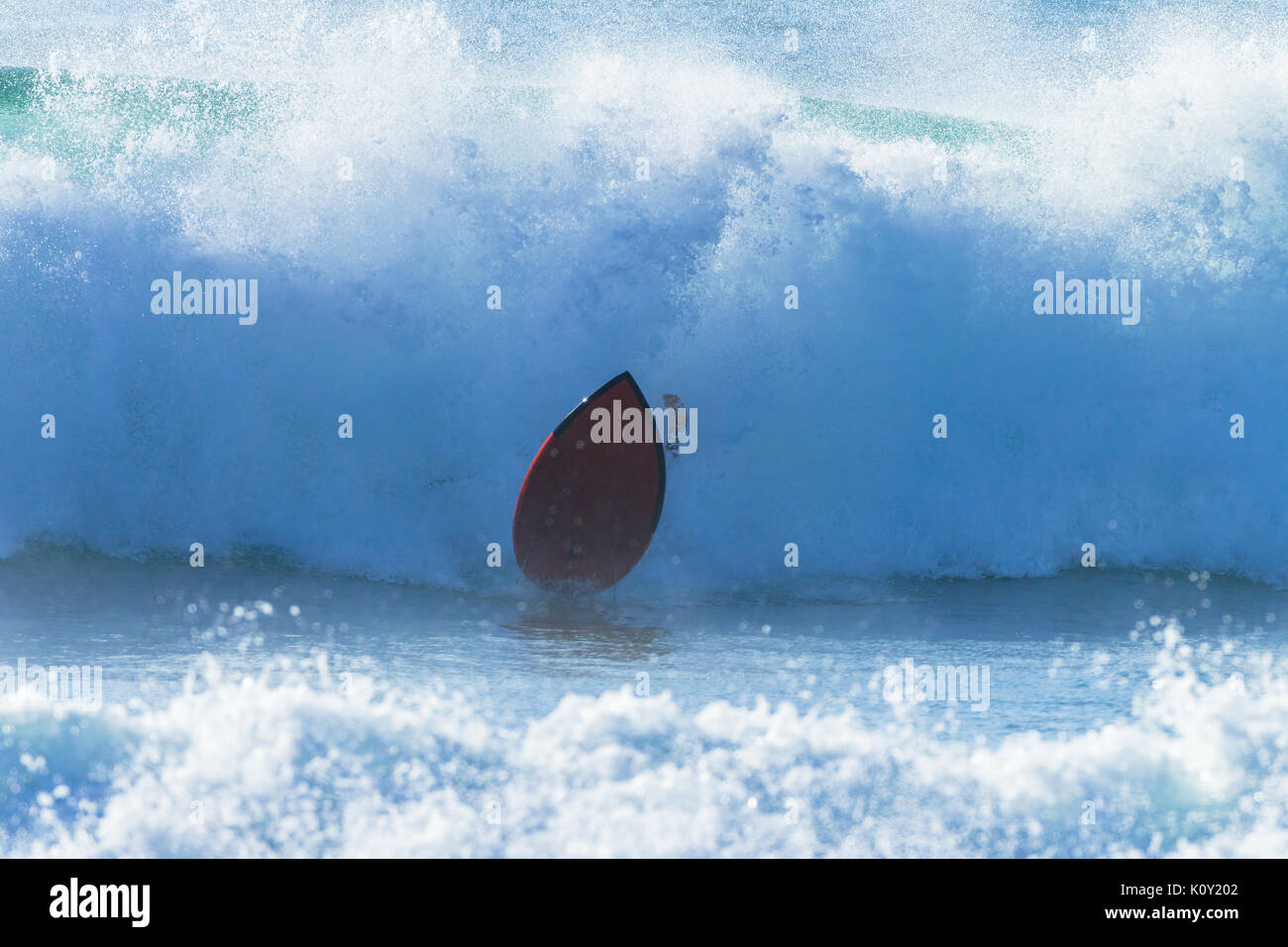 Surfer Surfen Absturz verlässt Vorstand und Ocean Wave dramatische schwarz-weiß Foto. Stockfoto