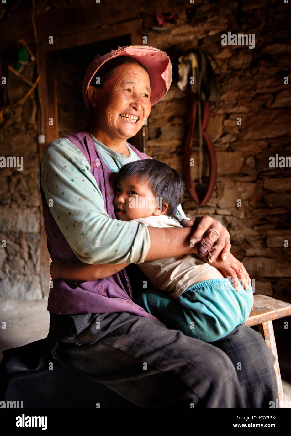 Tibetische Mutter und Kind an ihr traditionelles Haus in einem Dorf in der Nähe von Kunming, Provinz Gyarong, Kham, tibetischen Plateau Stockfoto