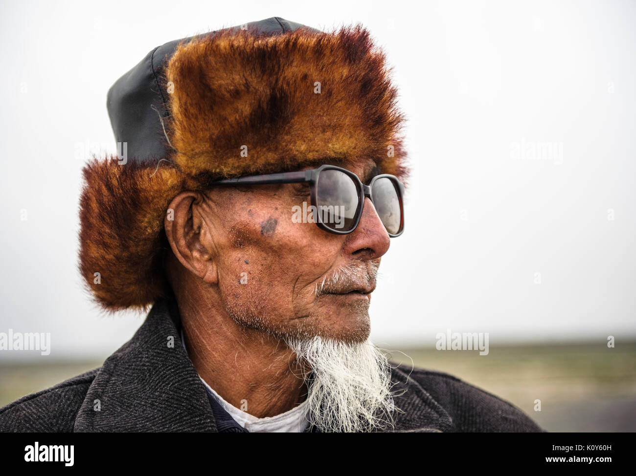 Eine mongolische Mann mit einem traditionellen Hut. Xinjiang Stockfoto