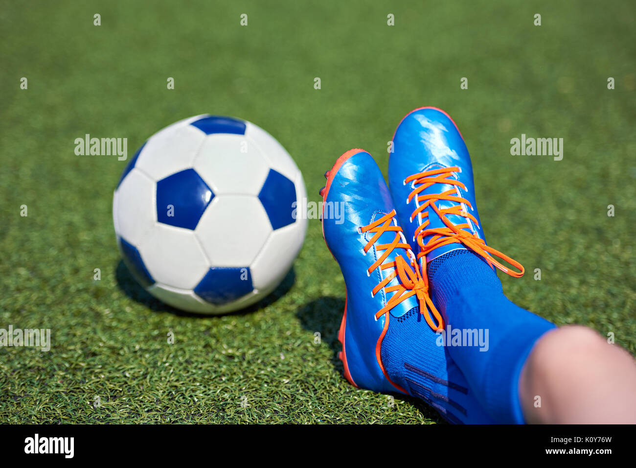 Foots der junge Fußballspieler in Fußballschuhe mit Ball auf Gras Stockfoto