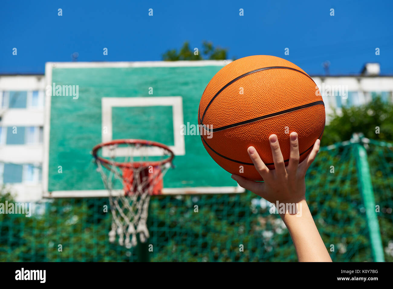 Hand mit einem Basketball auf dem Hintergrund eines Schildes mit einem Korb  Stockfotografie - Alamy