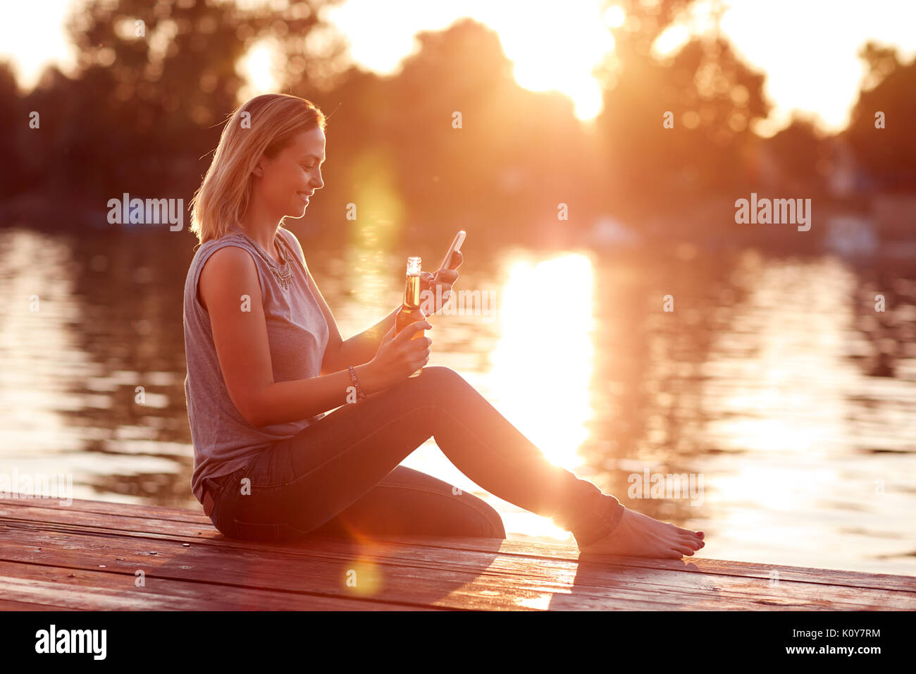 Junge Frau genießen und erfrischt durch den Fluss bei Sonnenuntergang Stockfoto