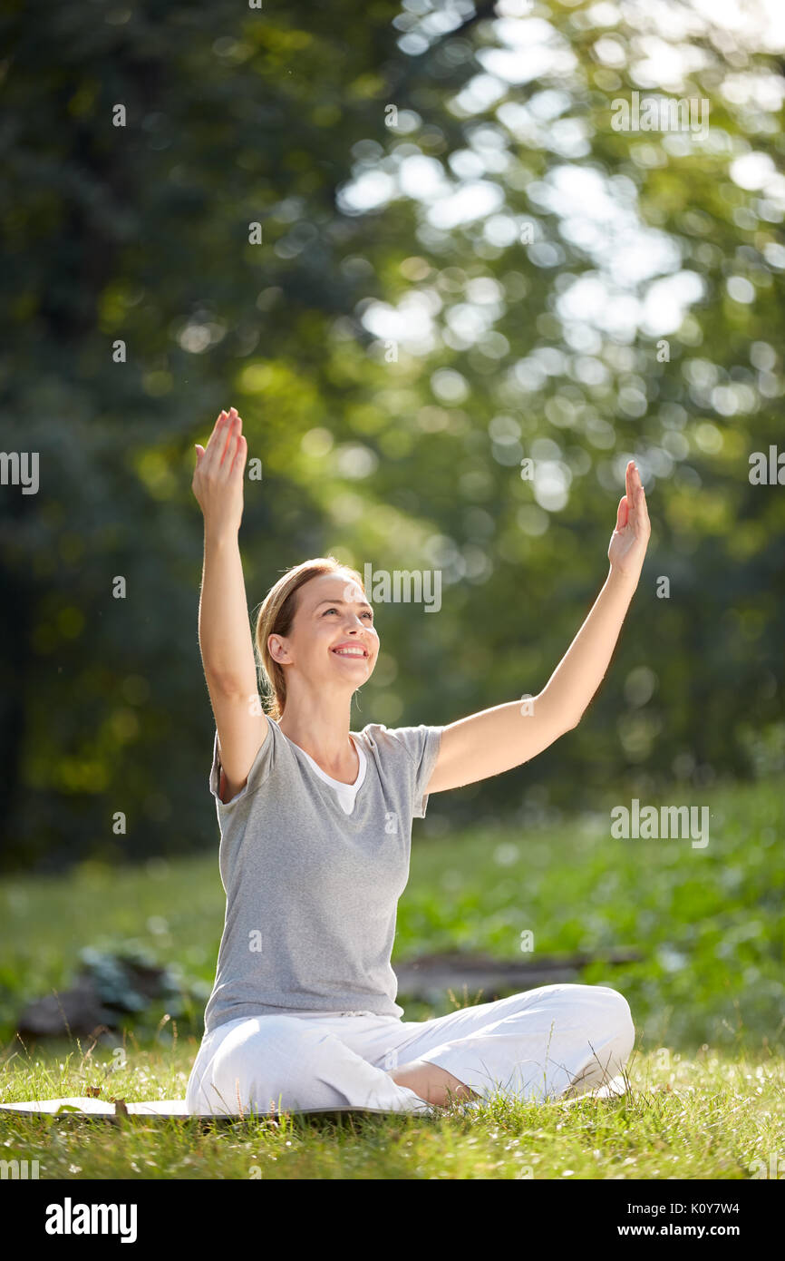 Ältere Frau Yoga in der grünen Natur Stockfoto