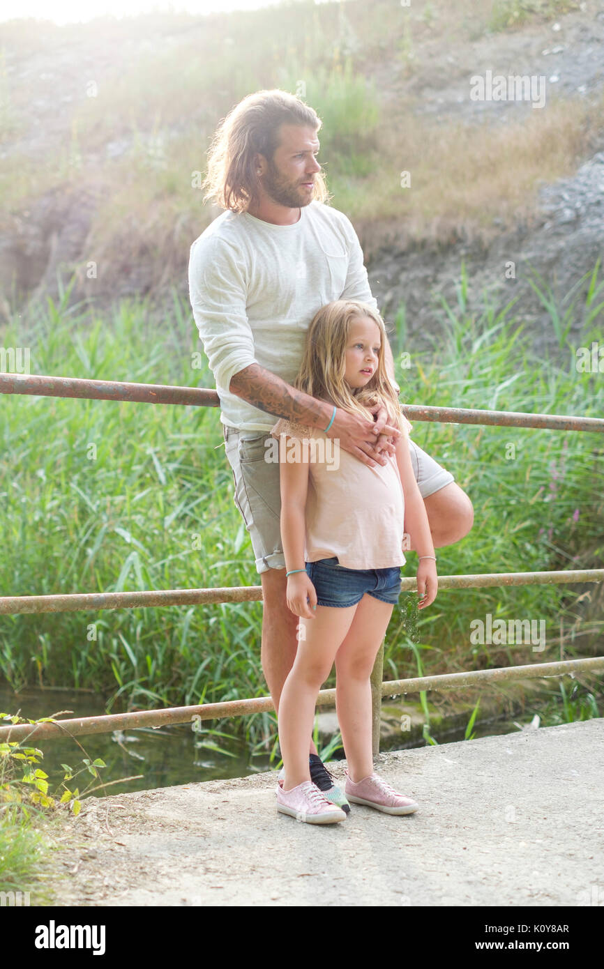 Vater und Tochter steht auf einer Brücke von einem Fluss Stockfoto