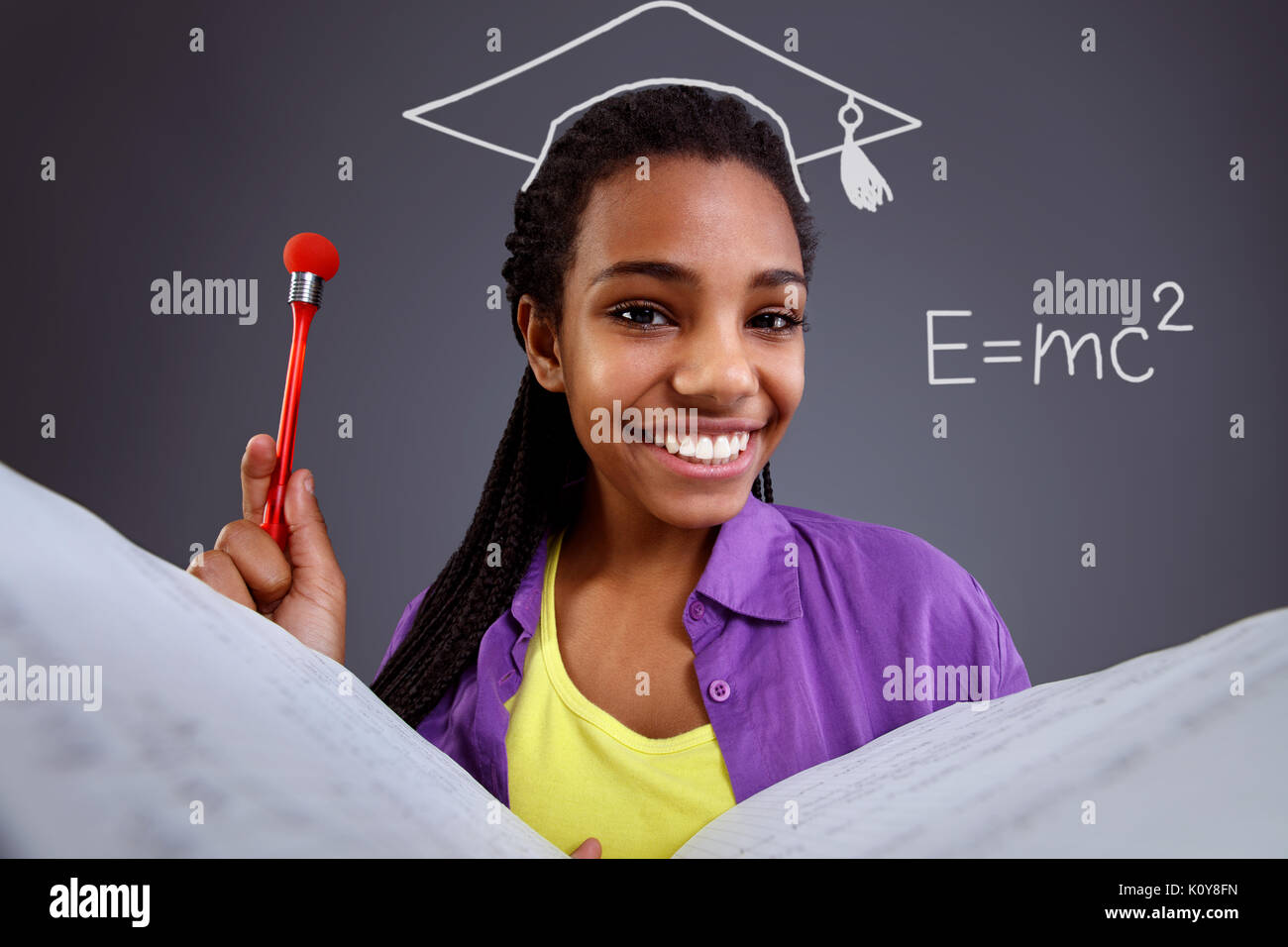 Erziehung in der Schule - glückliche Schülerin dabei mathematische Gleichungen Stockfoto