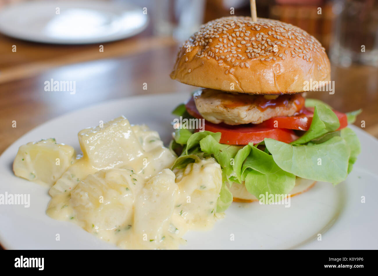 Hamburger, Hähnchen und Bratkartoffeln auf dem Teller. Stockfoto