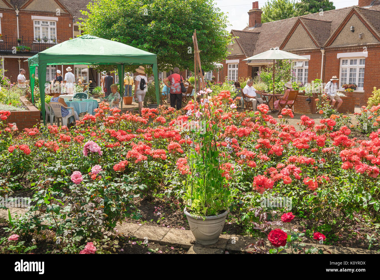 Sommer Garden Party, an einem Sommernachmittag Menschen besuchen den Garten des Maynewater Lane Almosen Häuser in Bury St Edmunds offenen Gärten Tag, Suffolk, Großbritannien Stockfoto
