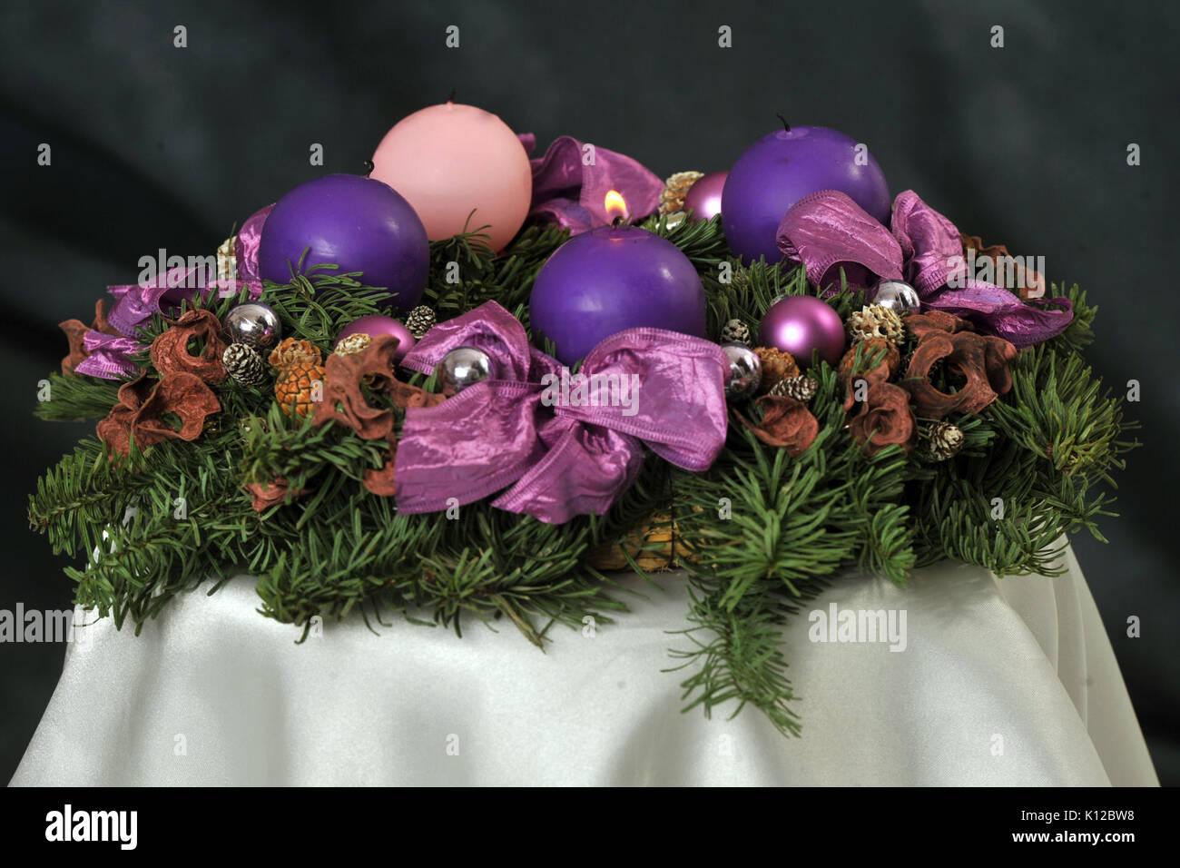 Adventskranz mit Veilchen und Rose Kerzen 1. Stockfoto