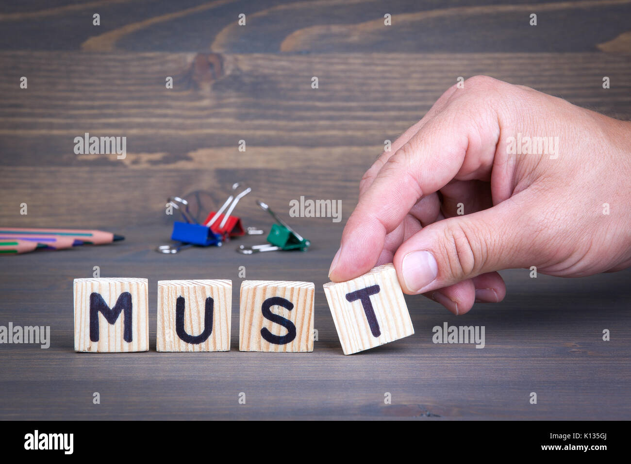 Müssen aus Holz Buchstaben auf Holz- Hintergrund Stockfoto