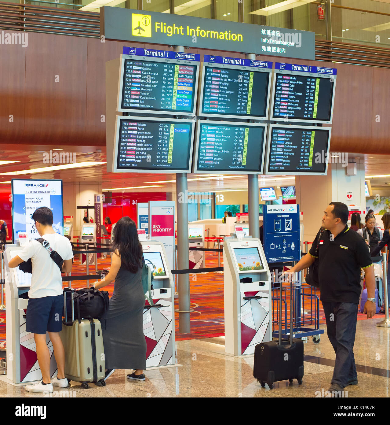 Singapur - Januar 13, 2017: Passagiere am Check-in-Automaten in der Nähe der Information Board in Changi Airport. Changi Airport dient mehr als 100 Airlines Stockfoto